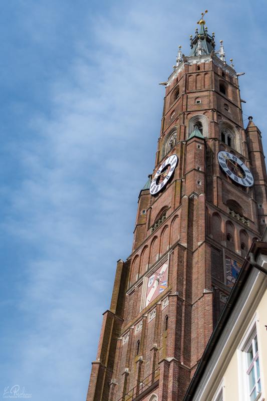 Bell tower of St. Martin in Landshut against blue sky with some white clouds
