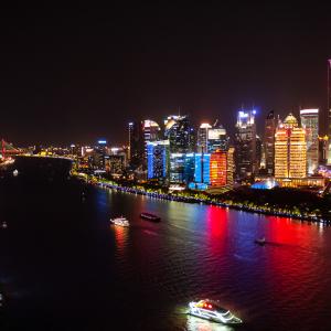 View of the Huangpu River in Shanghai at night. Buildings shines with bright colors. The oriental pearl tower can be seen