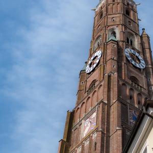 Bell tower of St. Martin in Landshut against blue sky with some white clouds